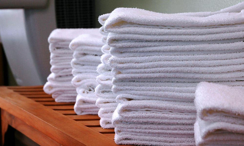 Stacks of gym towels on wood bench