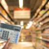 Calculator in supermarket aisle - calculating energy needs