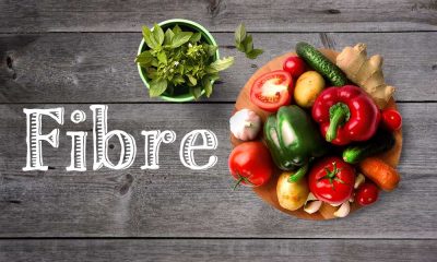 Fibre in white text with assortment of vegetables and basil plant in pot